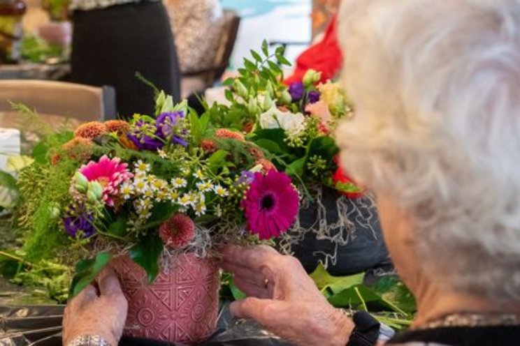 Tuinbouwjongeren en ouderen bloemschikken